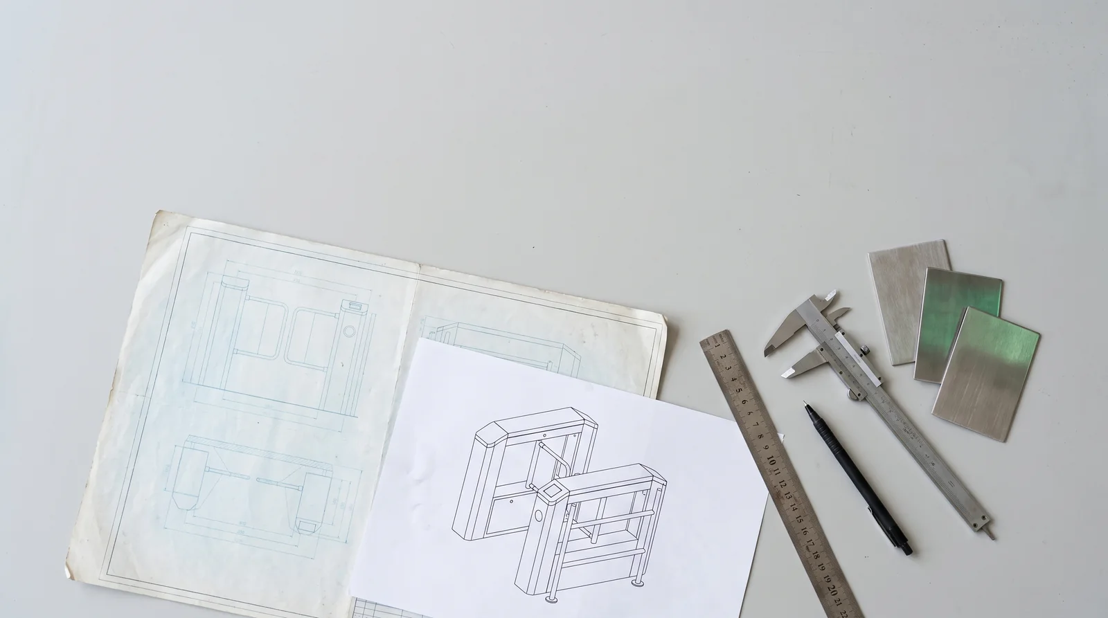 A hygiene station drawing, caliper, ruler and metal samples on a desk