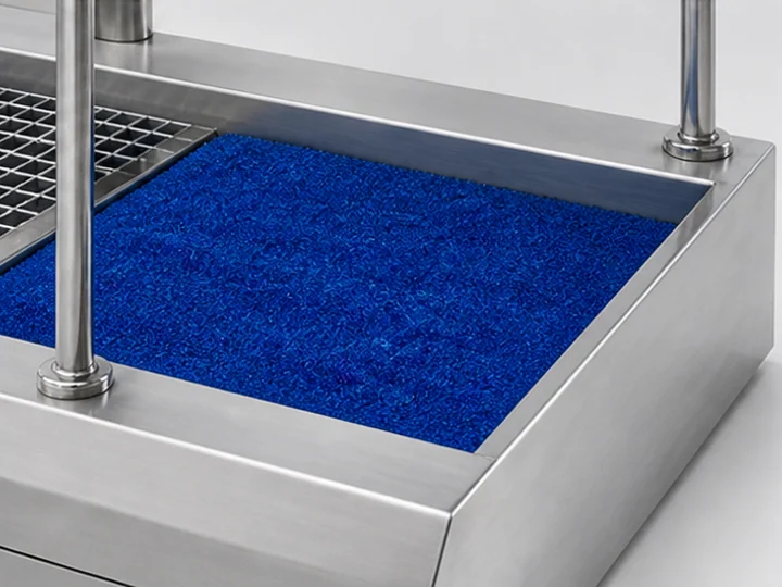A blue moisture-removal mat beside a hygiene station’s grated platform